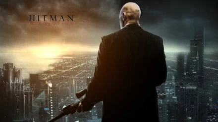 A dramatic HD wallpaper from the video game Hitman: Absolution, featuring the enigmatic protagonist looking over a city skyline at dusk.