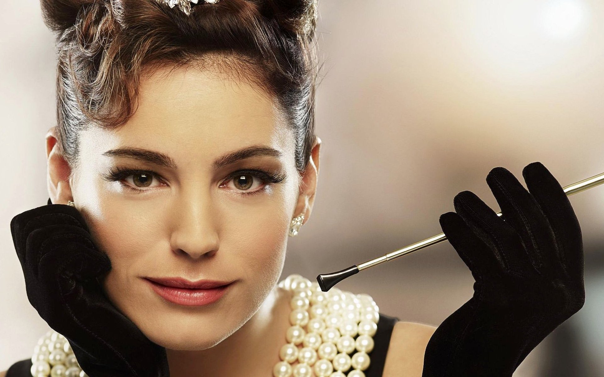 HD desktop wallpaper featuring a close-up portrait of celebrity Kelly Brook wearing black gloves and pearl jewelry against a softly blurred background.