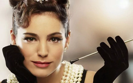 HD desktop wallpaper featuring a close-up portrait of celebrity Kelly Brook wearing black gloves and pearl jewelry against a softly blurred background.