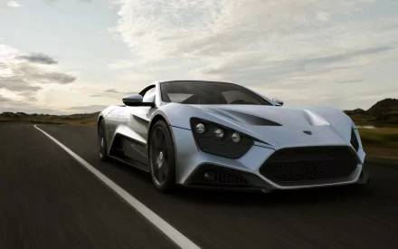 Silver Zenvo ST1 supercar on an open road beneath dramatic clouds — HD PC desktop wallpaper and background.