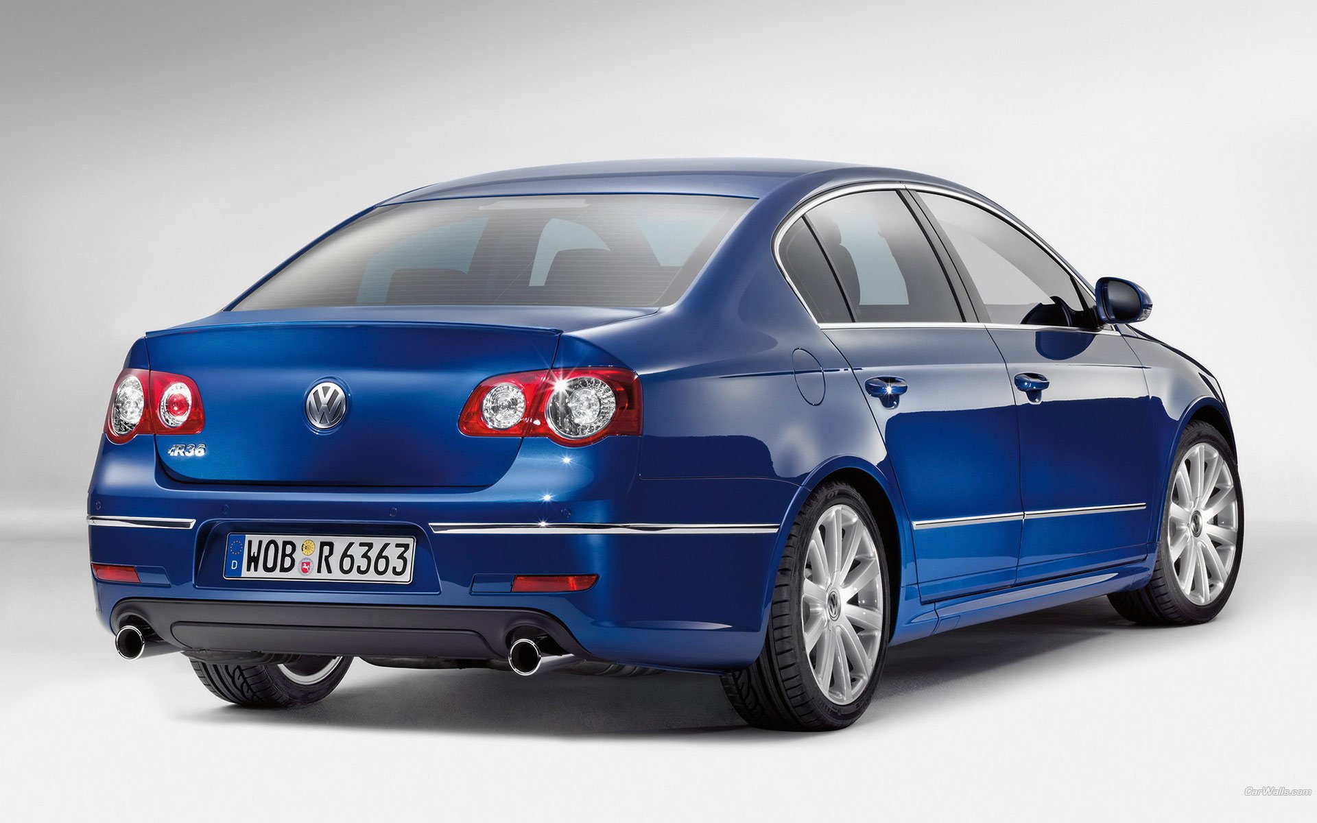 Blue Volkswagen sedan, rear three-quarter view on a clean gray backdrop — HD PC desktop wallpaper/background.