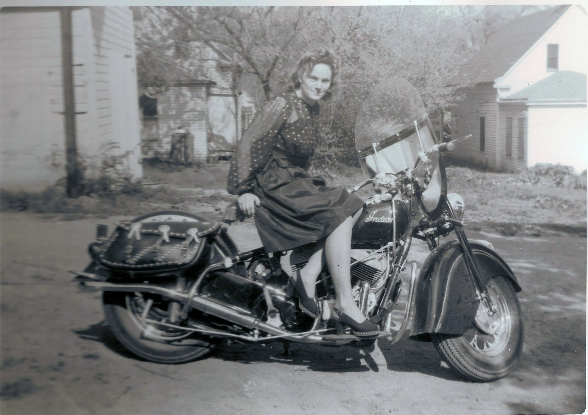 Black-and-white 4K Ultra HD desktop wallpaper of a vintage motorcycle with a woman seated outdoors in a residential area.