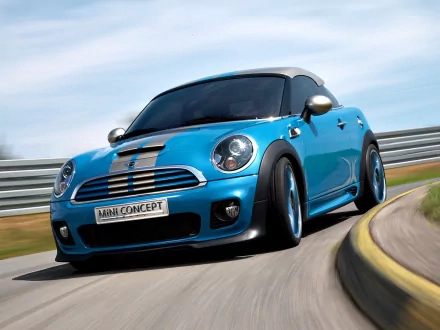 HD PC desktop wallpaper background: blue Mini Cooper vehicle taking a curved track turn, sporty Mini concept car captured in dynamic motion.