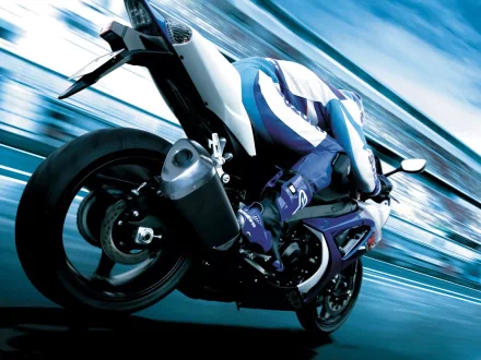 HD PC desktop wallpaper featuring a dynamic motorcycle speeding through a blurred urban background, capturing motion and energy in a sleek vehicular design.