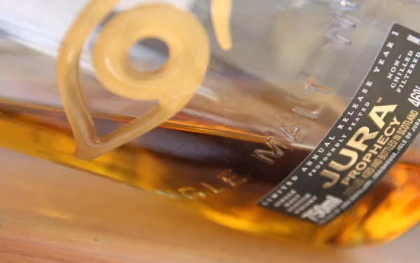 Close-up of a Jura whisky bottle, showcasing its rich amber liquid and detailed label. A stunning 4K Ultra HD image capturing the essence of Scotch malt.