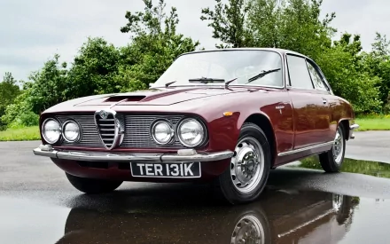 Maroon Alfa Romeo 2600 Sprint on wet pavement reflecting clouds, front three-quarter view — HD PC desktop wallpaper background featuring a classic vehicle