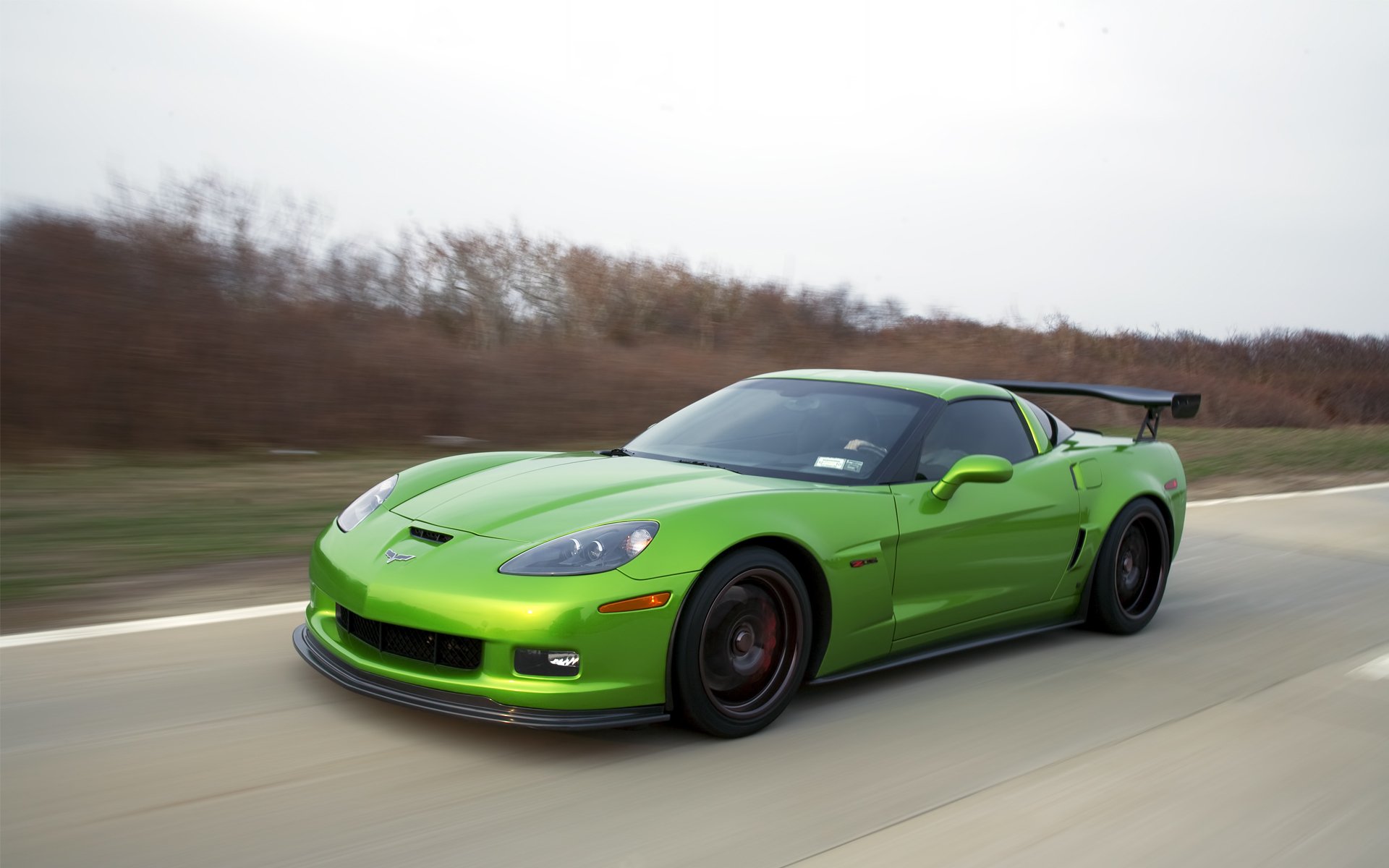 HD PC desktop wallpaper/background of a green Chevrolet Corvette vehicle speeding along an open road.