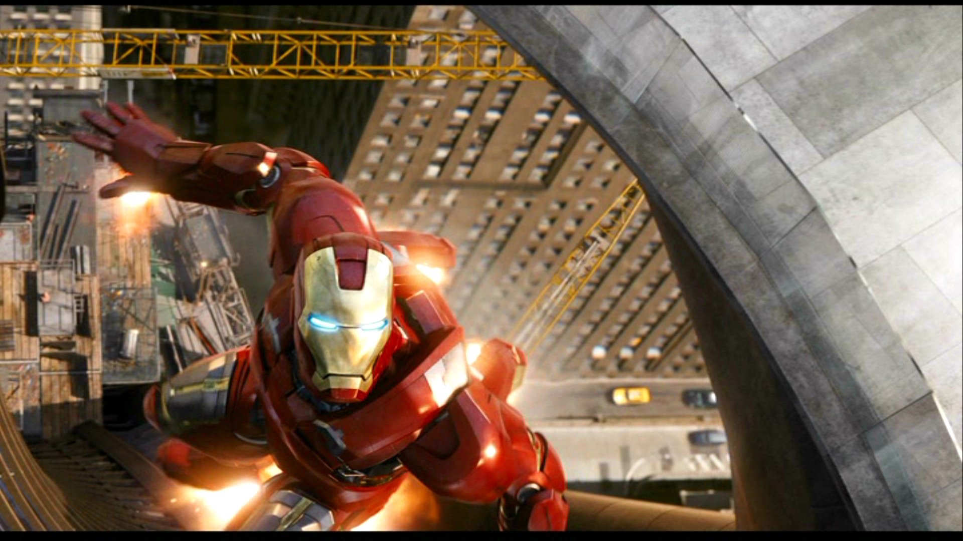 HD desktop wallpaper of Iron Man from The Avengers movie, featuring Iron Man flying through a cityscape with skyscrapers and bright lights in the background.