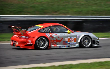 HD PC desktop wallpaper: red-and-silver Porsche race car (#45) tearing along a racetrack, motion-blurred backdrop and grassy runoff.