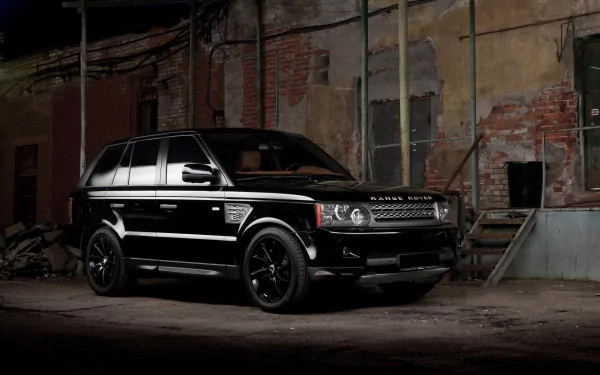 HD PC desktop wallpaper featuring a sleek black Range Rover parked in an industrial, dimly lit setting.
