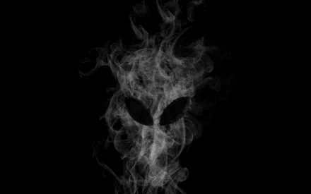 HD Alienware desktop wallpaper featuring a smoky, ethereal alien face design set against a black background, emphasizing technology and futuristic themes.