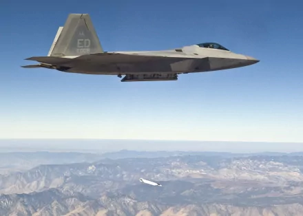 A Lockheed Martin F-22 Raptor flies over mountainous terrain, showcasing its advanced military design in a high-definition desktop wallpaper.