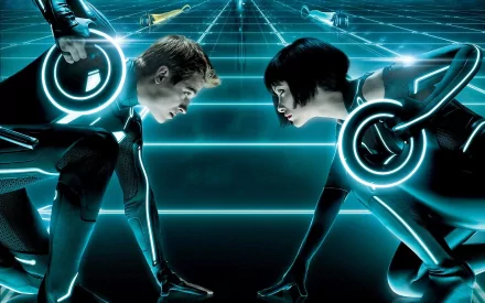 A high-definition wallpaper featuring Olivia Wilde as Quorra and Garrett Hedlund as Sam Flynn, set against the glowing digital landscape of TRON: Legacy.