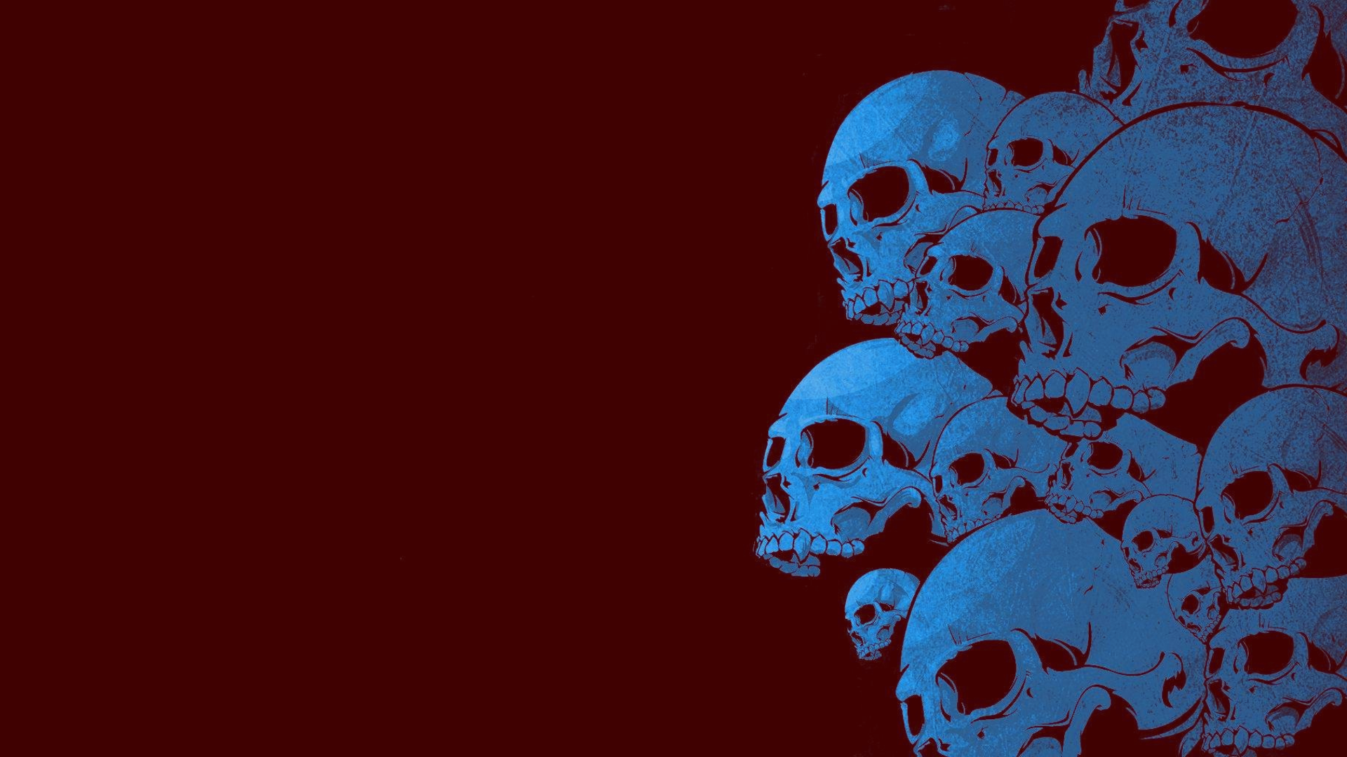 HD PC desktop wallpaper featuring a cluster of blue skulls on a dark red background, creating a bold and eerie visual impact.