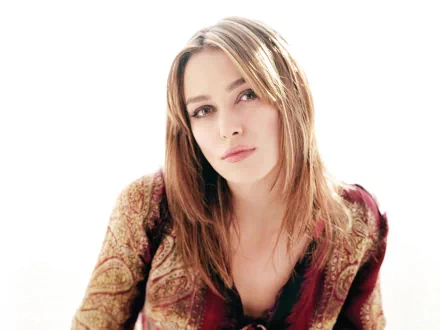 HD desktop wallpaper featuring celebrity Keira Knightley, with a soft, ethereal background highlighting her serene expression and intricate patterned clothing.