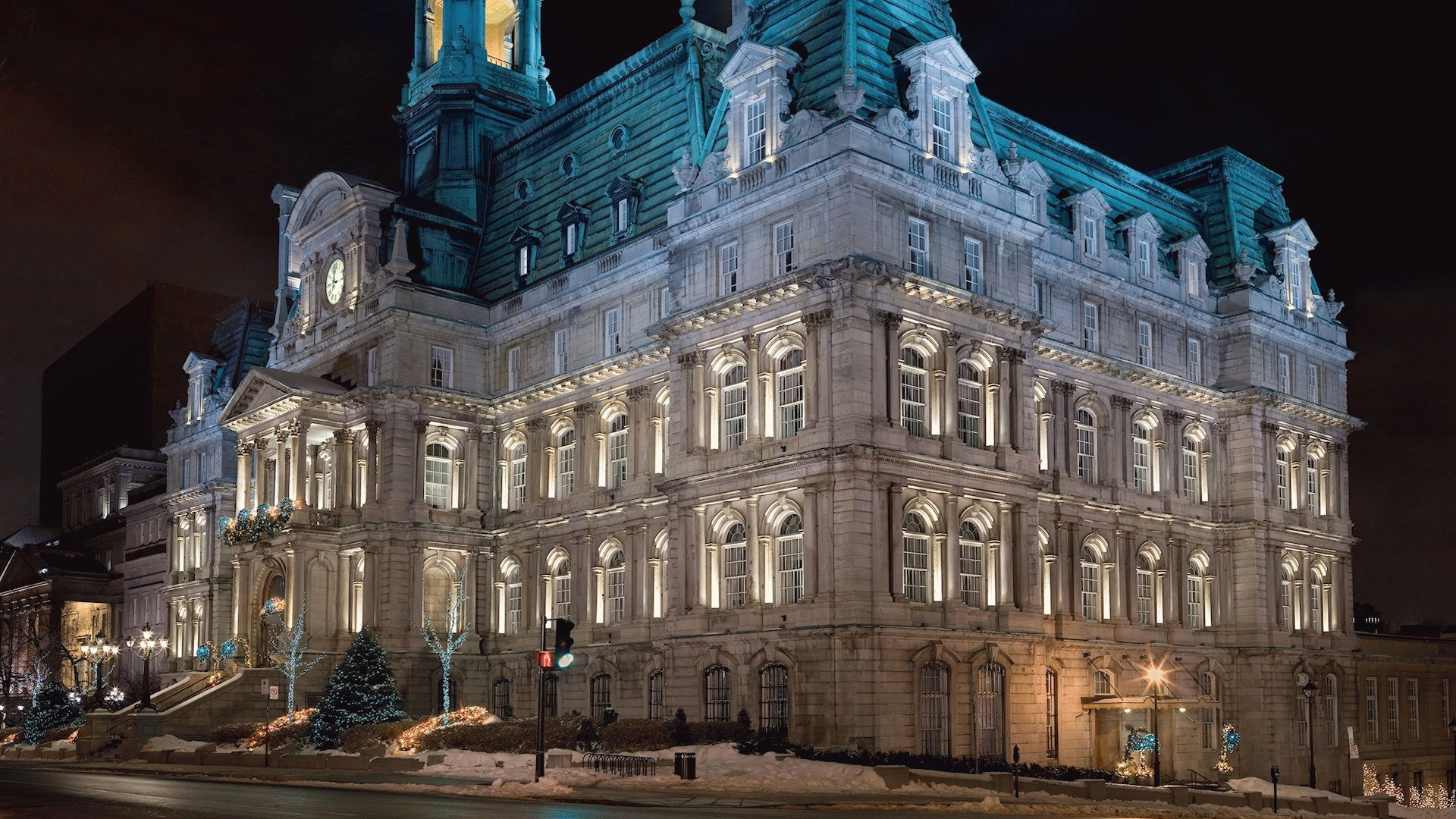 HD PC desktop wallpaper/background: illuminated man-made mansion at night — ornate stone façade, green patina roof, arched windows and street lamps on a snowy urban avenue.
