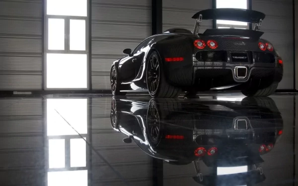 Sleek black Bugatti sports car reflected on a polished hangar floor, captured as an HD PC desktop wallpaper and background.