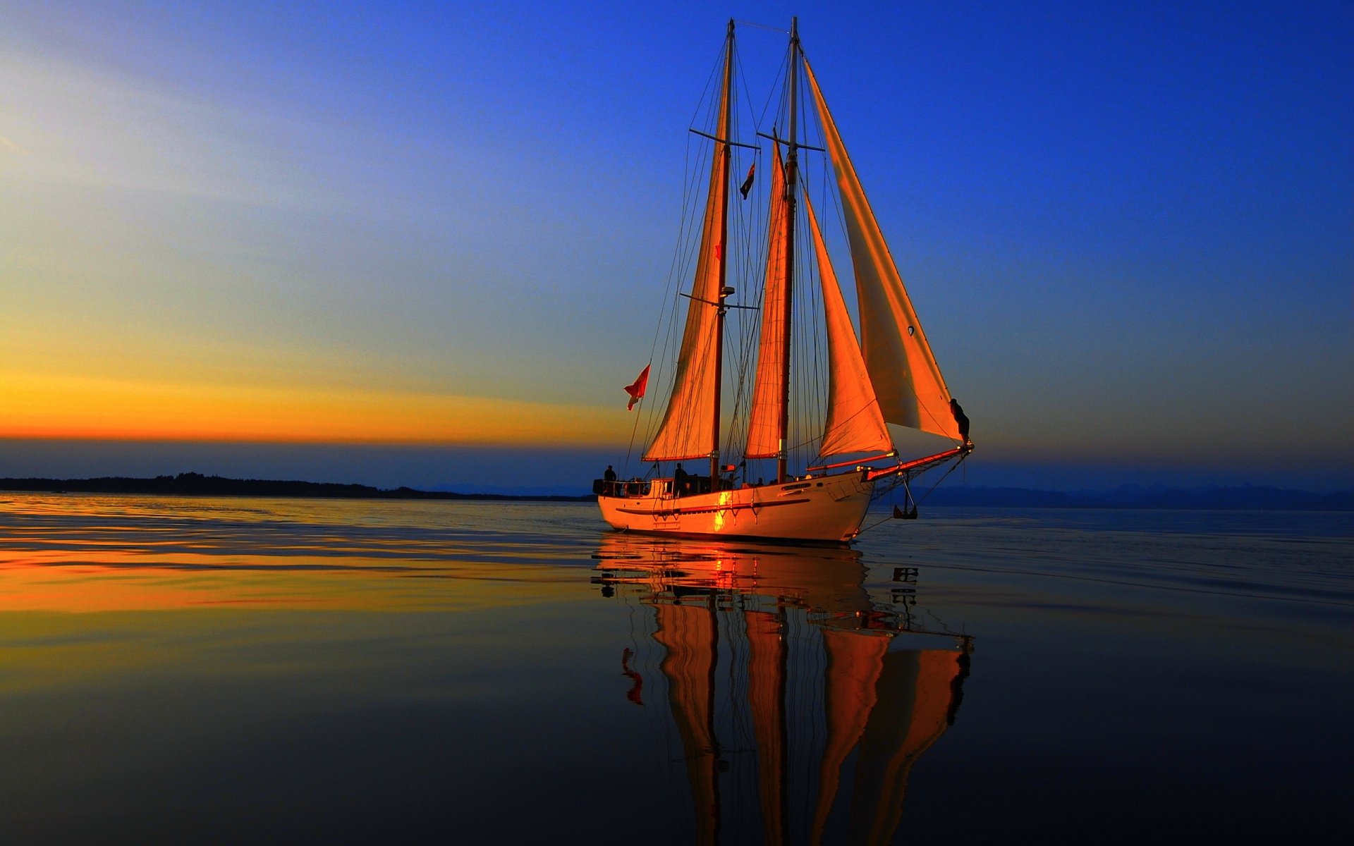 HD PC desktop wallpaper and background: a ship (vehicle) — a two‑masted sailing vessel with glowing orange sails reflected on calm water at sunset.