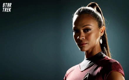 Zoe Saldana as Nyota Uhura in Star Trek, captured in a striking HD desktop wallpaper, showcasing her powerful presence against a dark background.