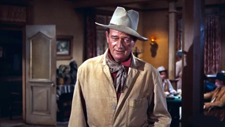 John Wayne in a classic Western look, wearing a tan jacket and white hat, captured in a moment indoors. This HD image serves as a striking PC desktop wallpaper.