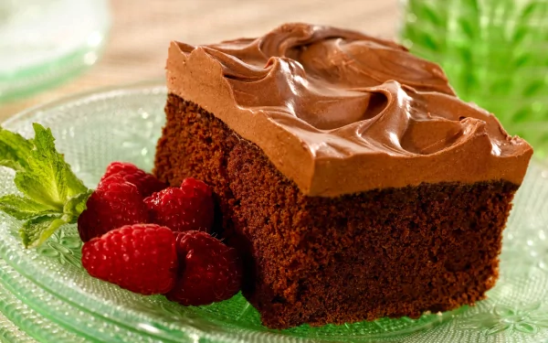 Slice of chocolate cake with smooth chocolate icing, raspberries and mint on a plate — sweets food dessert; 2K Quad HD PC desktop wallpaper background.
