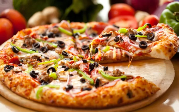 A delicious, freshly baked pizza topped with pepperoni, olives, and green peppers, displayed on a wooden board, set against a vibrant background of fresh vegetables. HD desktop wallpaper.