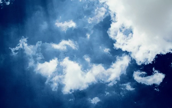 A serene HD desktop wallpaper featuring a clear blue sky adorned with fluffy white clouds, capturing the beauty of nature.
