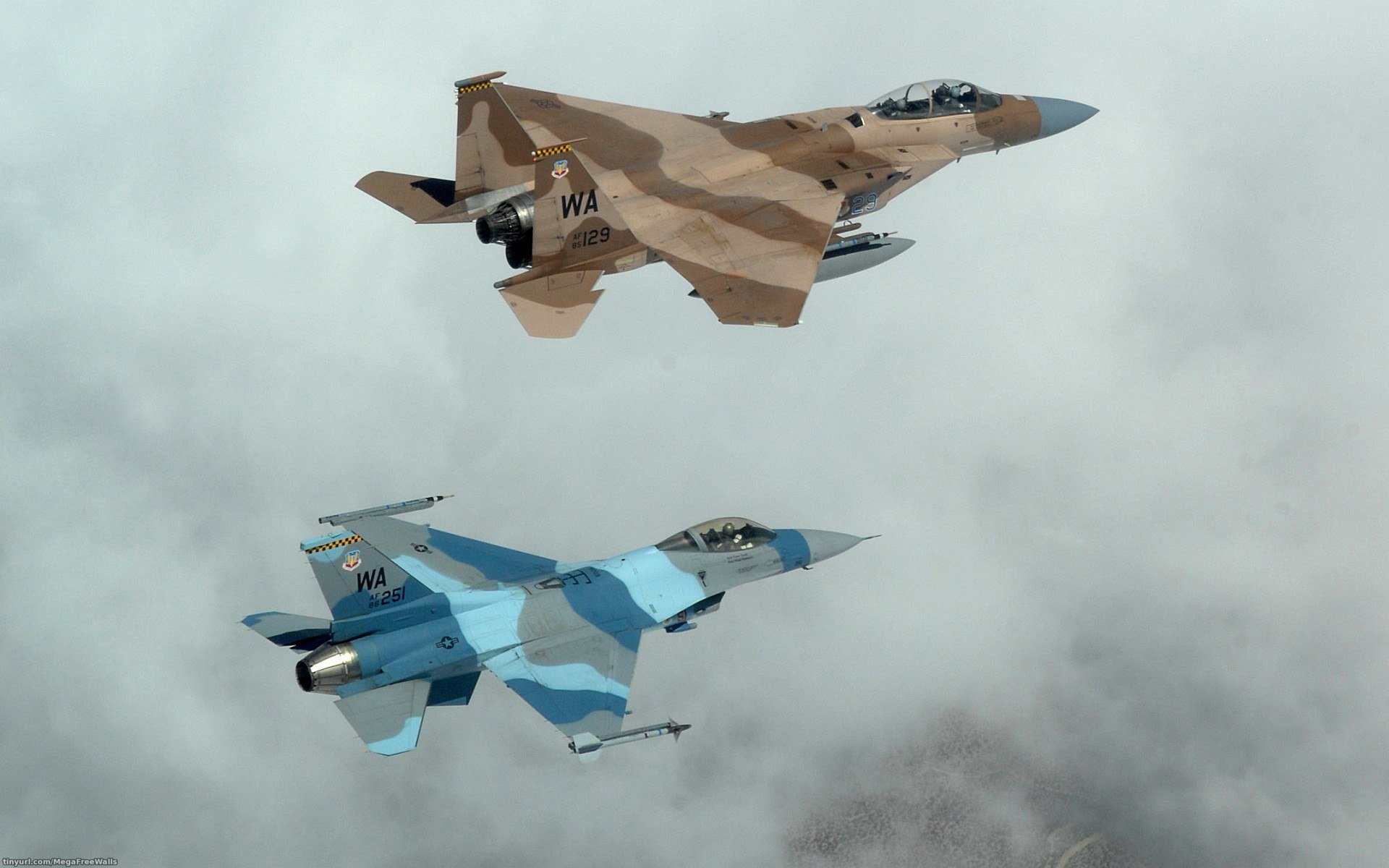HD desktop wallpaper showing a McDonnell Douglas F-15 Eagle and a General Dynamics F-16 Fighting Falcon jet fighter flying against a cloudy sky.