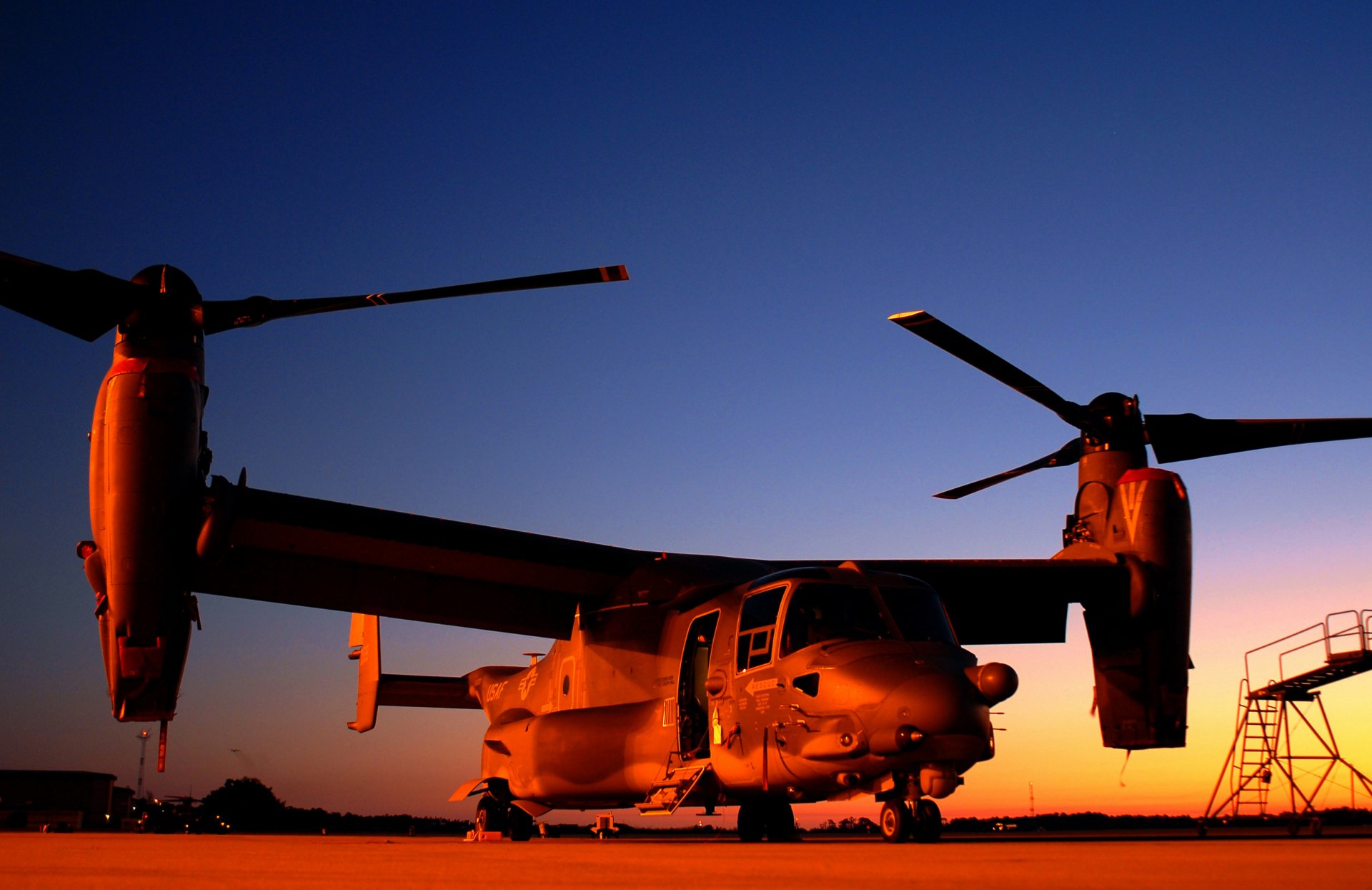HD desktop wallpaper of a Bell Boeing V-22 Osprey tiltrotor aircraft on the ground at sunset, representing Air Force military aviation.