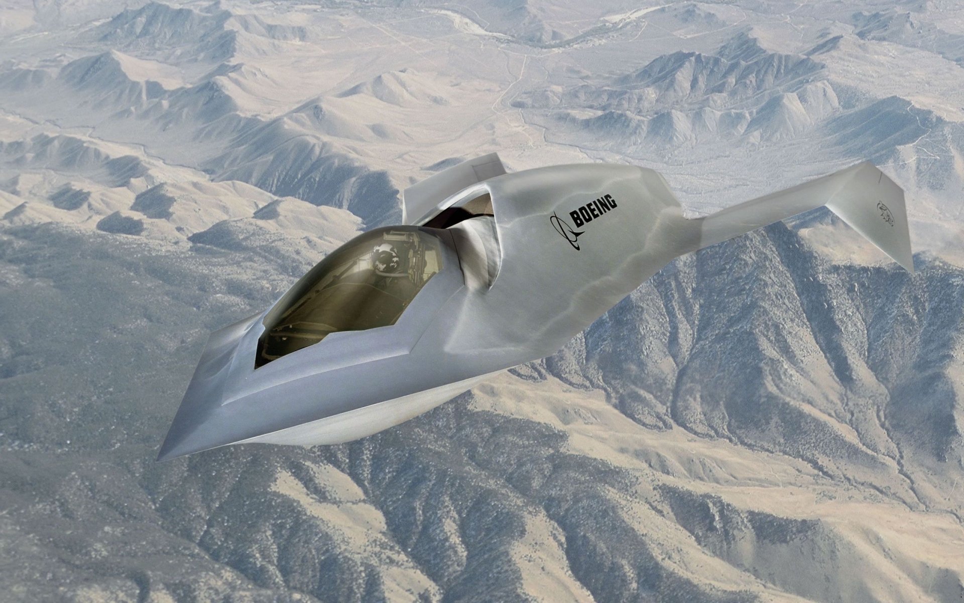 Boeing Bird of Prey stealth military aircraft soaring above desert mountains — 2K Quad HD PC desktop wallpaper.