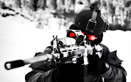HD desktop wallpaper featuring a sniper from Call of Duty: Modern Warfare 2, in a dark tactical outfit aiming through a rifle scope. The background shows a snowy landscape with blurred trees.