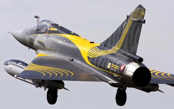 HD desktop wallpaper featuring a military Dassault Mirage 2000 fighter jet in flight with black and yellow accent markings.