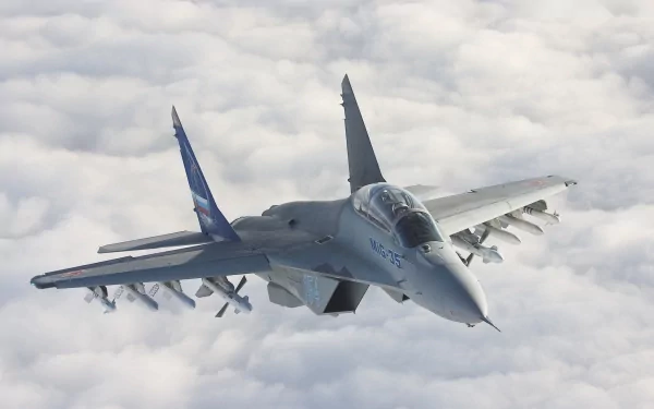 A Mikoyan MiG-35 military jet soars above the clouds, showcasing its sleek design and advanced capabilities. A striking HD wallpaper for aviation enthusiasts.