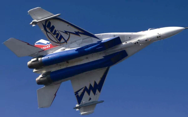 HD PC desktop wallpaper featuring a Mikoyan MiG-29 military jet soaring against a clear blue sky.