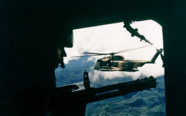 Silhouetted crew view from a transport door framing a Sikorsky MH-53 helicopter over cloud-covered jungle — military HD PC desktop wallpaper/background.