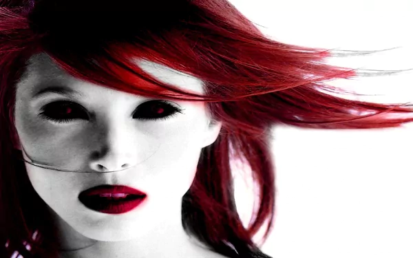 A striking HD wallpaper featuring a gothic, dark aesthetic. The image showcases a woman with vibrant red hair and dramatic makeup, creating an intense and captivating look.