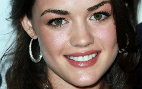 Close-up HD desktop wallpaper of celebrity Lucy Hale smiling, showcasing her natural makeup and hoop earrings.