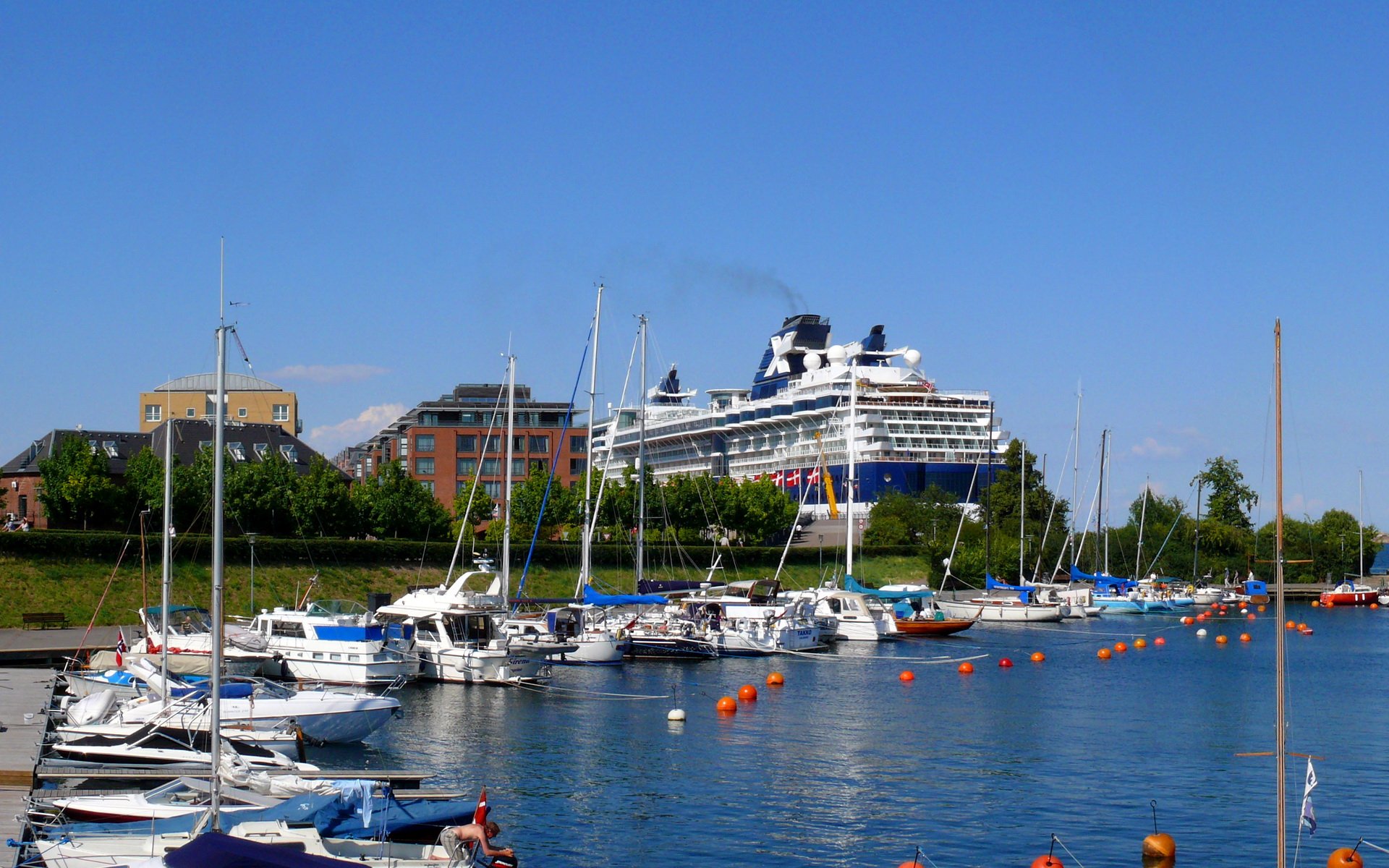 HD PC desktop wallpaper featuring a large cruise ship docked near a marina with sailboats, set against a clear blue sky.