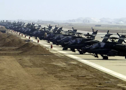 HD desktop wallpaper featuring a long row of military helicopters lined up on a tarmac in a foggy airbase setting.