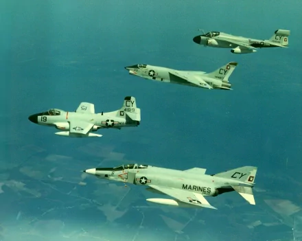 HD PC desktop wallpaper featuring a military air squadron of vintage jet fighters flying over a clear blue sky.