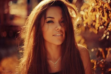 HD desktop wallpaper featuring a woman with long hair, exuding a sensual vibe, set against a warm, autumnal background.