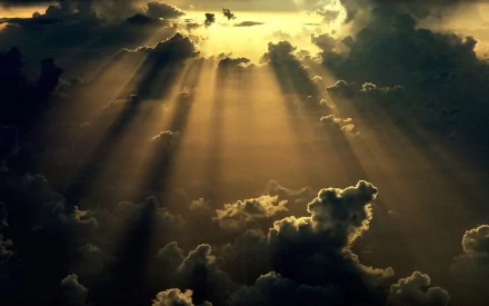 A breathtaking HD desktop wallpaper featuring sunbeams breaking through dark clouds, highlighting the beauty of nature and the sky.
