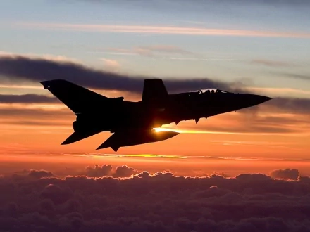 A stunning HD desktop wallpaper featuring a Panavia Tornado jet silhouetted against a vibrant sunset, showcasing military aviation against a dramatic sky.