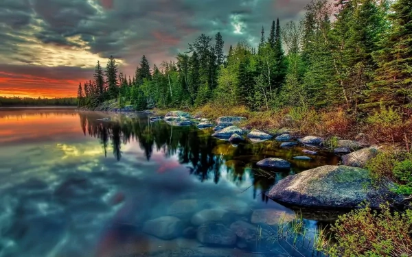 A stunning HD wallpaper of a tranquil lake surrounded by lush trees, reflecting vibrant colors in the water, enhanced by HDR photography for a captivating natural scene.