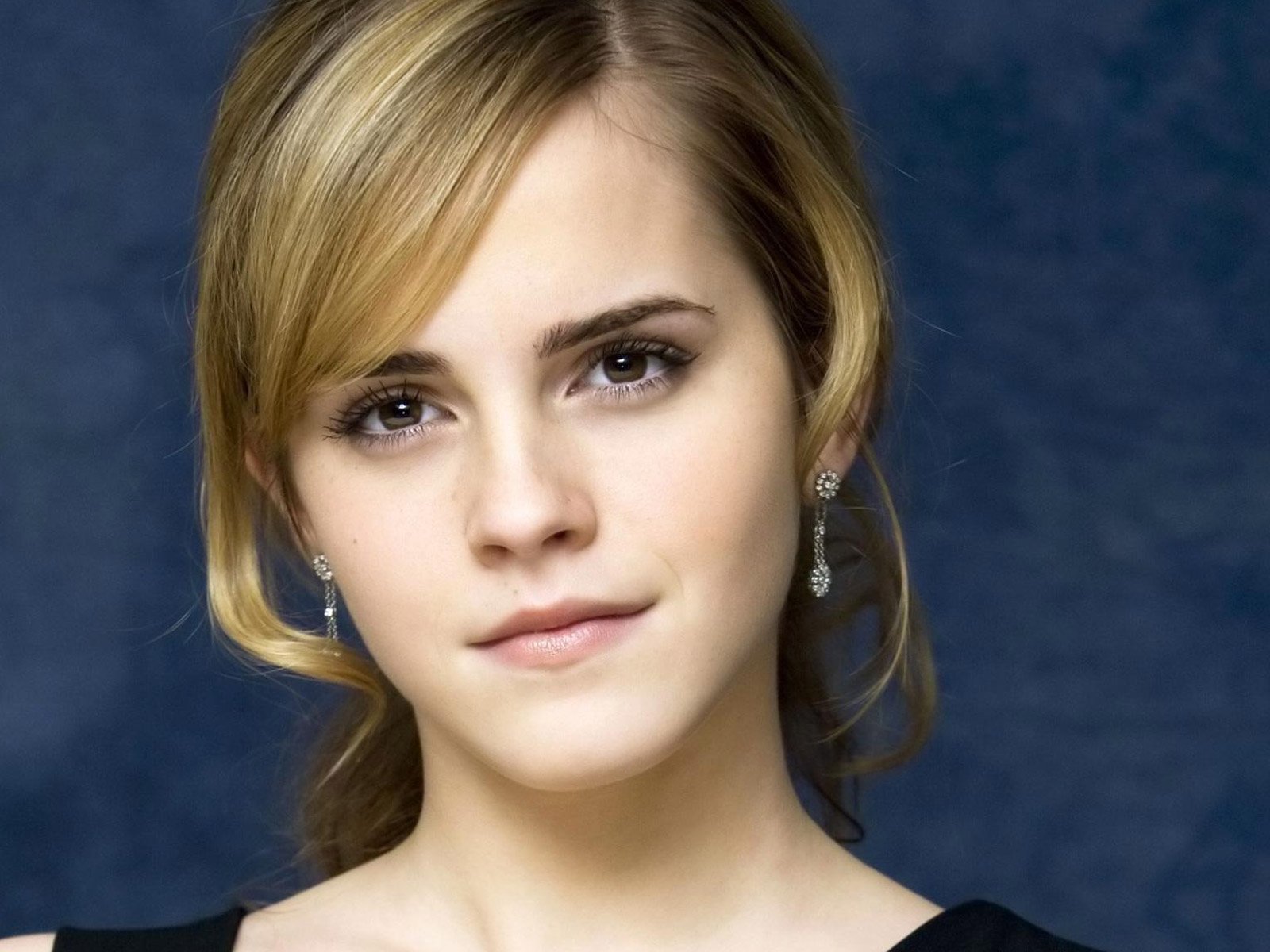 A striking HD wallpaper featuring celebrity Emma Watson, showcasing her elegant beauty against a soft, blue background.