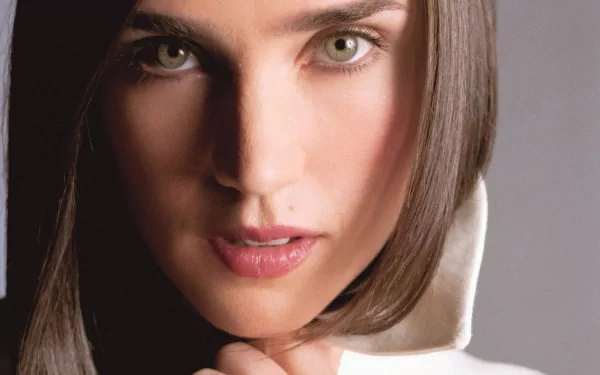 A captivating HD desktop wallpaper featuring actress Jennifer Connelly, showcasing her striking green eyes and elegant pose against a soft background.