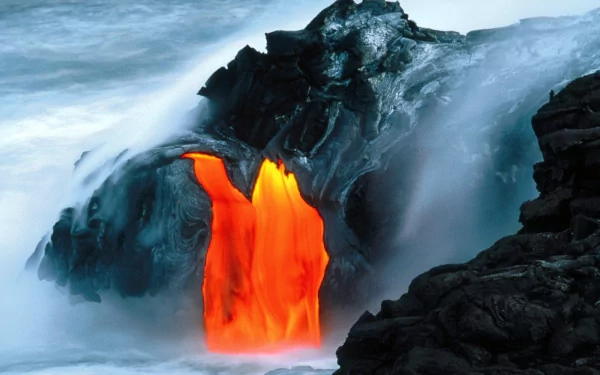HD wallpaper of a dramatic volcanic scene where fiery lava flows from a black rock formation into the ocean, surrounded by mist and steam. Taken from nature, it makes an engaging desktop background.