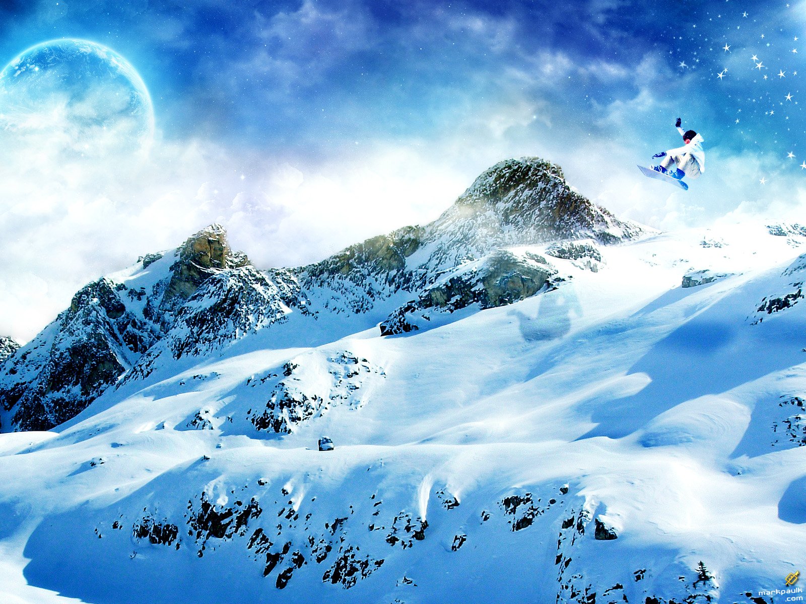 HD desktop wallpaper showing a snowboarder mid-air above snow-covered mountains under a bright blue sky, capturing the thrill of snowboarding and winter sports.