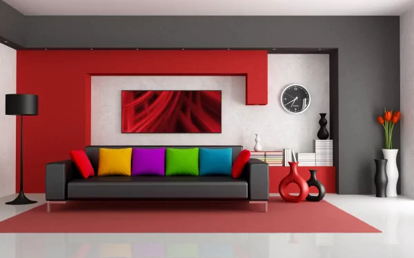 A stylish living room features a colorful sofa with vibrant pillows, set against a modern backdrop of red and gray walls. Complemented by sleek decor and artistic accents.