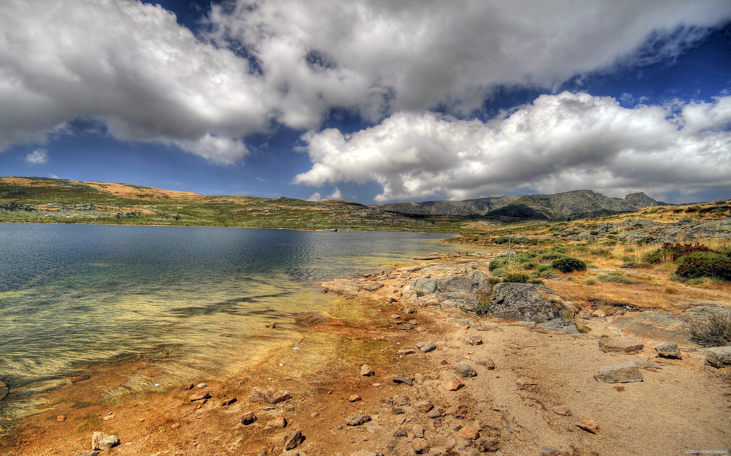 Mountain landscape by a serene lake with a cloudy sky
